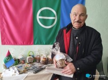 Переселенець з Бахмута тримає пасочку, передану від громад-партнерів