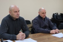 Члени наради сидять за столом.