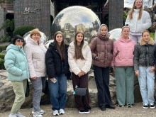 Учні Соледарської громади біля фасаду гостинці, позаду них дзеркальна куля.