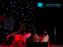 Хлопці у народних костюмах сидять у кругу, дія с музичної вистави.