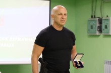 Вадим Філашкін тримає в руках нагрудний знак.