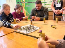 Діти разом із військовослужбовцем у процесі виготовлення свічок