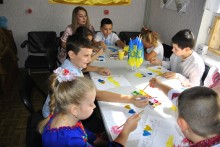 Діти за столом малюють композиції з державними символами України