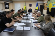 Учасники засідання Ради оборони Донецької області сидять за столом