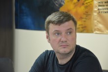 Начальник управління з питань інформатизації та цифровізації Донецької ОДА Володимир Білокопитний. Сидить за столом позаду прапори військових бригад.