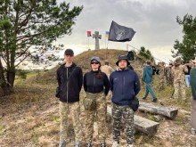 Молодь Донеччини на меморіальному місці з прапорами та хрестом під час табору.