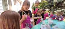 Діти стоять біля столу та засипають до повітряних кульок крохмаль