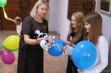 Жінка дарує дітям кульки та іграшки