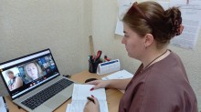 Представник військової адміністрації сидить за столом та слухає доповідача на семінарі.