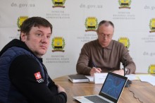 Учасники наради сидять за столом.