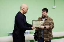 Вадим Філашкін вручає ветерану сертифікат на отримання житла.