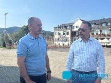 Начальник Покровської міської військової адміністрації Сергій Добряк та представник міста Хуст спілкуються на фоні будівлі.