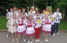 Діти і підлітки у національних костюмах тримають кубки, грамоти та медалі