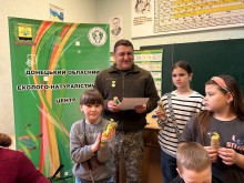 Військовослужбовець з подякою в руках, оточений дітьми