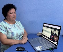 Представник військової адміністрації сидить за столом та слухає доповідача на семінарі.