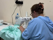 Жінка шиє адаптивний одяг для поранених захисників