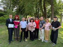 Спільне фото випускників та викладачів з квітами та дипломами у парку