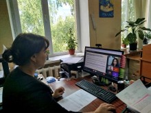 Представник військової адміністрації сидить за столом та слухає доповідача на семінарі