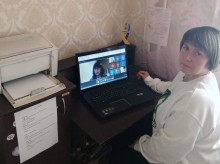 Представник військової адміністрації сидить за столом та слухає доповідача на семінарі