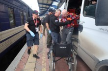 Команда БФ "Сзід SOS" вантажить речі людей старшого віку та з інвалідністю до евакуаційного потягу