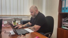 У світлому офісі за робочим столом сидить Артур Насібян - начальник управління з питань ветеранської політики Донецької області. Він приймає участь в онлайн зустрічі з ветеранами та членами родин загиблих (померлих) Захисників і Захисниць України Дружківської міської територіальної громади.