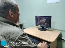 Учасник онлайн-турніру з шахів. Чоловік у сорочці сидить обличчям до монітора, на екрані рейтинг учасників.