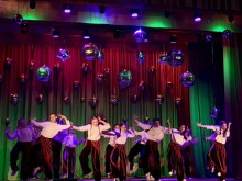 Танцювальний колектив виконує на сцені танок.