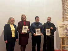 Учасники заходу (офіційні особи та священнослужитель) тримають у руках подарункові набори марок у рамах.