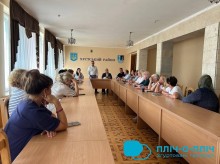 Робочий візит делегації Покровської громади до міста Хуст на Закарпатті. Делегації громад сидять за столом та обговорюють питання співпраці