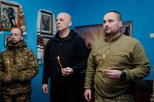 Вадим Філашкін та Геннадій Куций тримають у руках свічки під час молитви