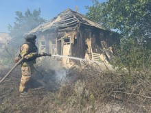 Пожежник гасить займання трави і гілок після удару окупантів