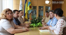 Представники Торецької громади та м. Ружина за столом обговорюють питання спільного майбутнього. Поруч прапори держави та громади.