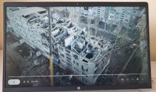 На екрані телевізора фотографія будинку після обстрілу.