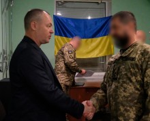 Заступник голови Ігор Бойко та військовослужбовець обмінюються рукостисканням, демонструючи повагу та співпрацю