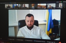 Представник міністерства сидить у кабінеті з боку прапор України.