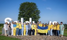 Діти та педагоги з Бахмутської громади біля напису «Saldus» у Латвії з прапором України.