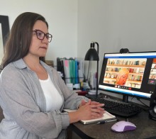 Представник військової адміністрації сидить за столом та слухає доповідача на семінарі
