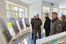 Представники громад розглядають фото відремонтованої школи.