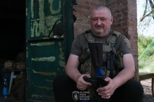 Віськовий сидить з автоматом