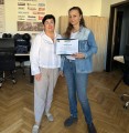Наталія Адамова вручає Юлії Паніній ваучери на проходження навчання