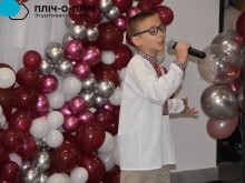 Хлопець у вишиванці співає. Позаду різнокольорові кульки.