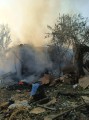 Зруйнований та згорілий одноповерховий будинок та пожежа на подвір'ї.