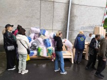 Група людей стоїть в черзі на отримання гуманітарної допомоги