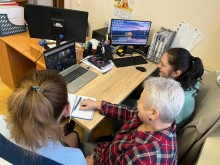 Представники військової адміністрації сидять за столом та слухають доповідача на семінарі