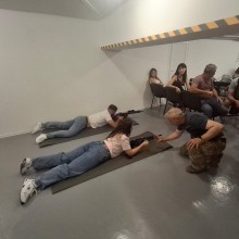 Інструктор показує як зайняти позицію лежачи для стрільби з автомата.