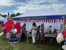 Люди в наметі з написом "Польська спільнота"