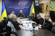 Учасники наради сидять за столом