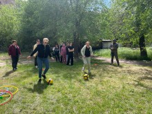 Група підлітків та дорослих разом з ветераном грають у спортивні ігри на галявині