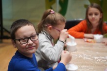 Хлопчик в окулярах та синьому светрі посміхається в камеру під час творчого майстер-класу.