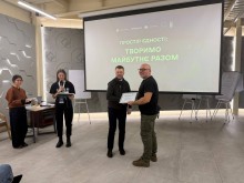 Начальник міської військової адміністрації Сергій Чаус тримає сертифікат учасника форуму, поруч стоїть представник громади